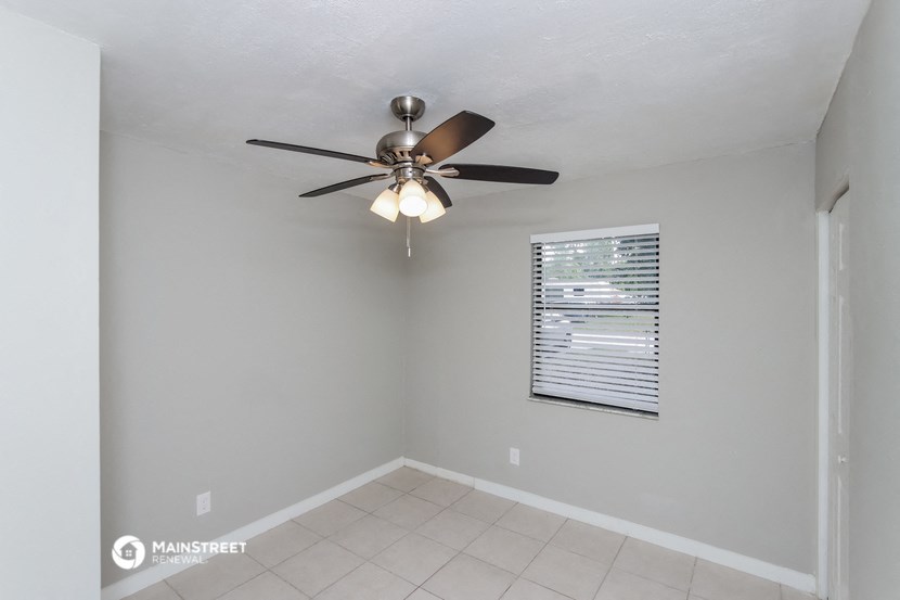 the living room has a ceiling fan and a tiled floor