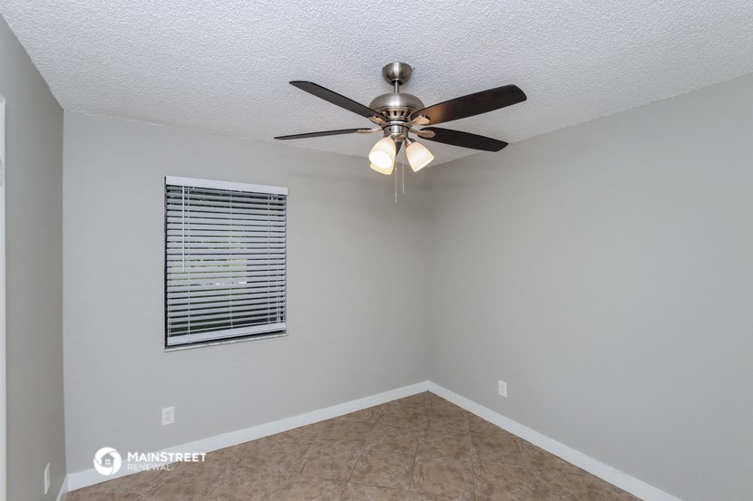 the bedroom has a ceiling fan and a window