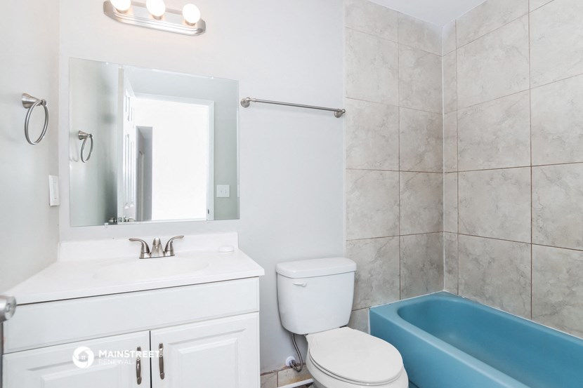 a bathroom with a blue bath tub and a sink and a toilet