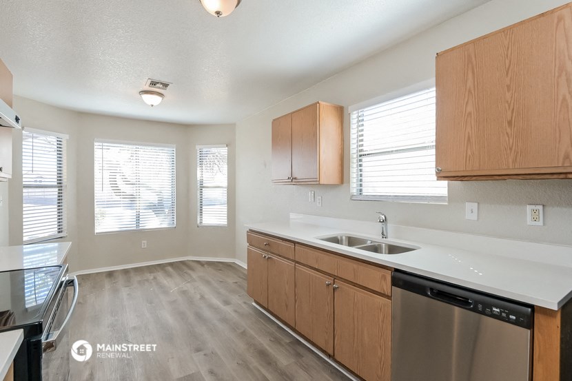 the kitchen of an apartment with wooden cabinets and a sink