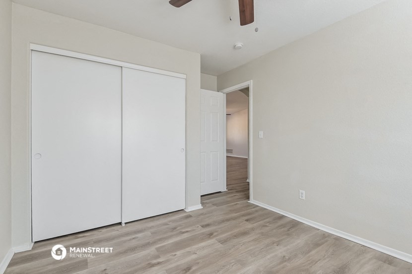 a bedroom with two closets and a door to a hallway