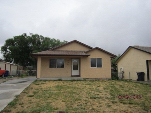 a beige house with a yard and a driveway