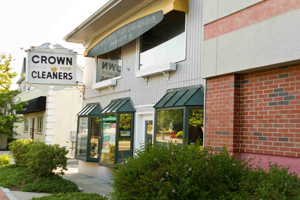 the front of a building with a sign for crown cleaners