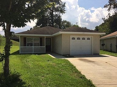 A small house with a white fence in front.