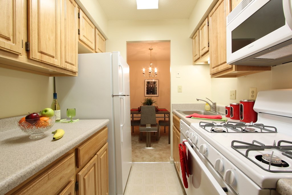 a kitchen with a stove and a refrigerator and a dining room