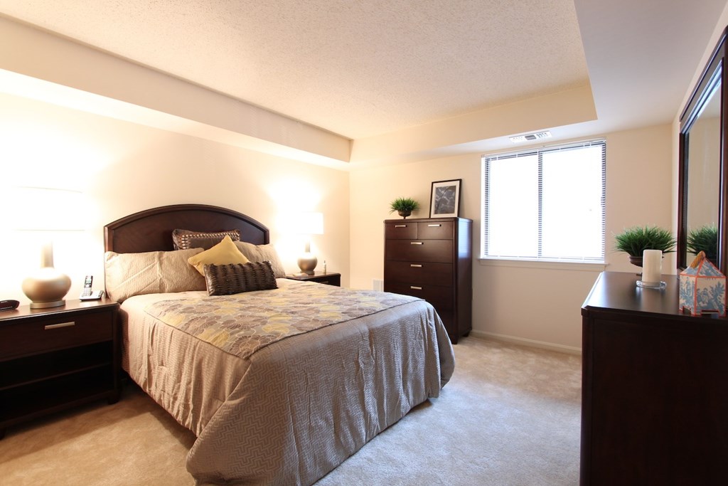 a bedroom with a bed and a dresser and a window