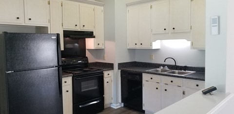 a kitchen with black appliances and white cabinets