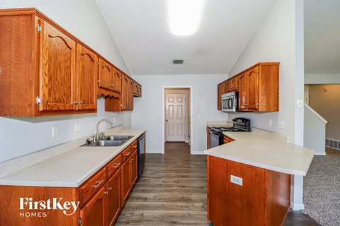 A kitchen with wooden cabinets and a white countertop.