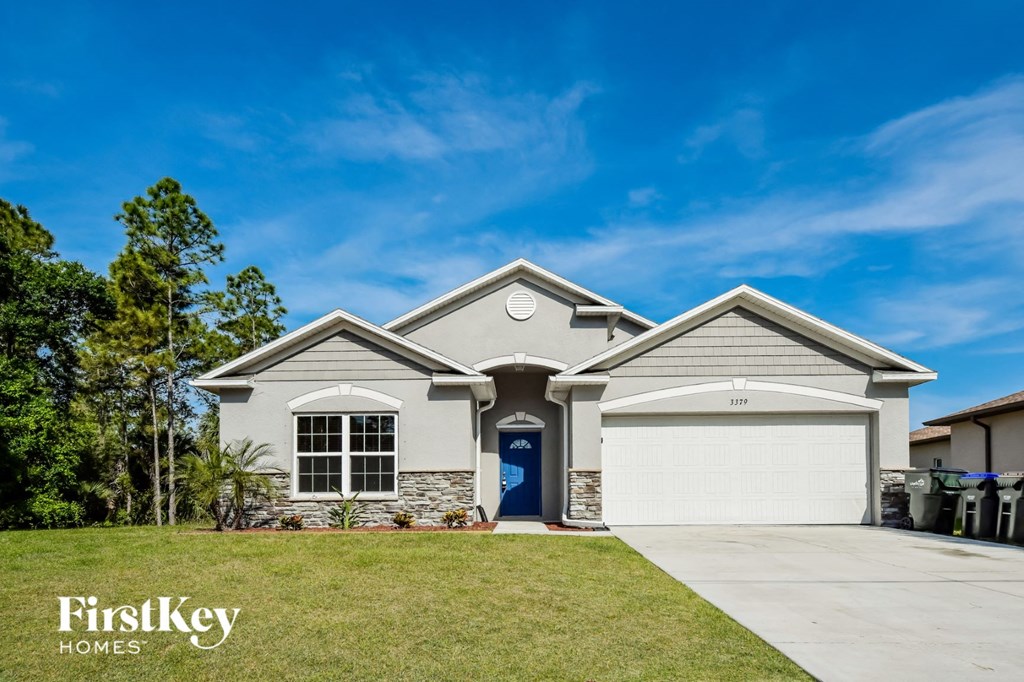 a house with a garage door and a lawn