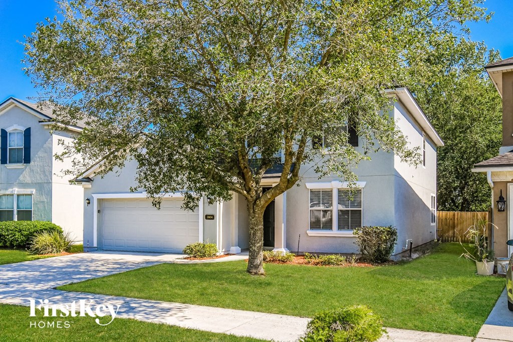 a white house with a tree in front of it