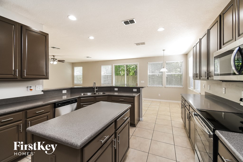 a large kitchen with granite counter tops and stainless steel appliances