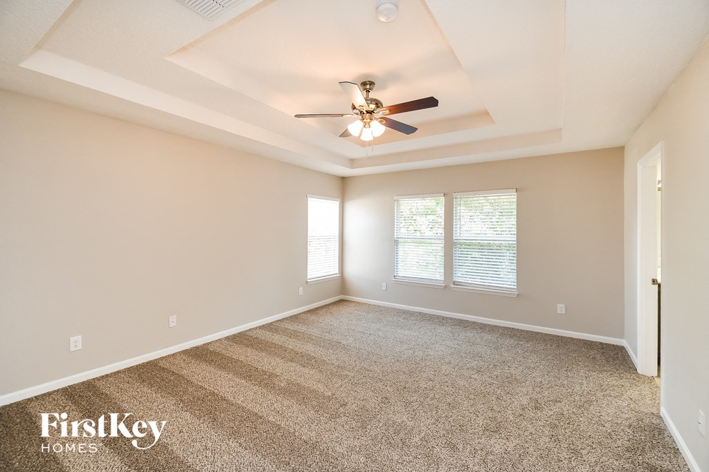 a living room with carpet and a ceiling fan