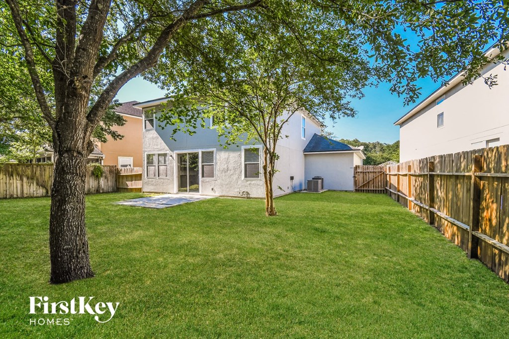 a backyard with a tree and a fence