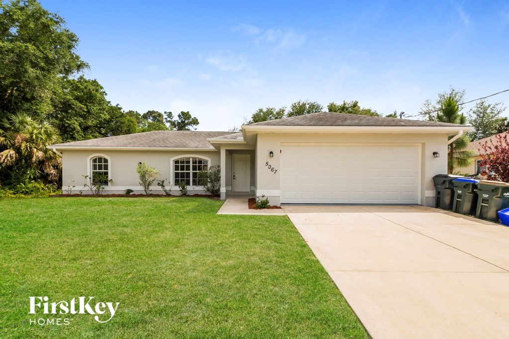 A white house with a garage is for sale by FirstKey Homes.