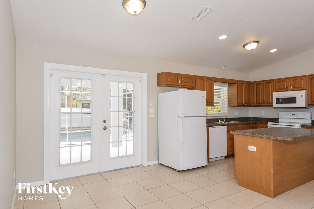 A kitchen with white appliances and wooden cabinets.