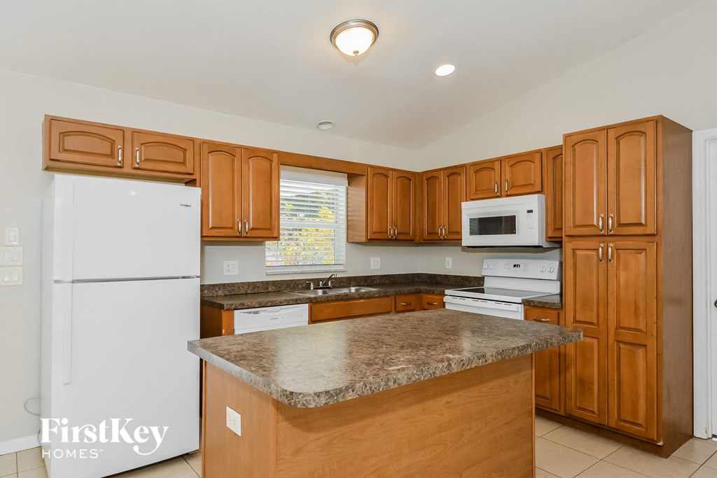 A kitchen with wooden cabinets and a granite countertop.