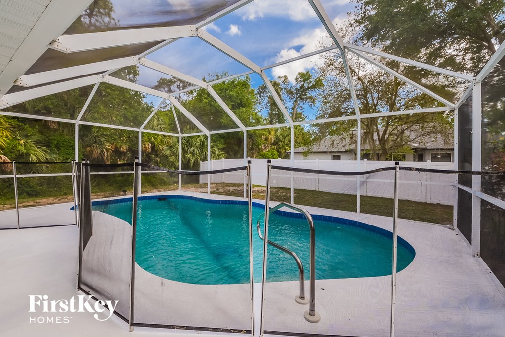 A pool enclosed by a white fence and a white roof.
