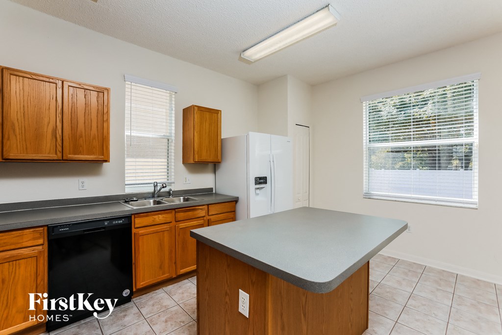 a kitchen with a counter top and a sink and a refrigerator