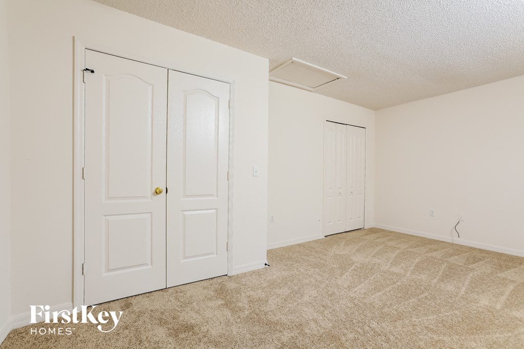 a bedroom with two closets and a carpeted floor
