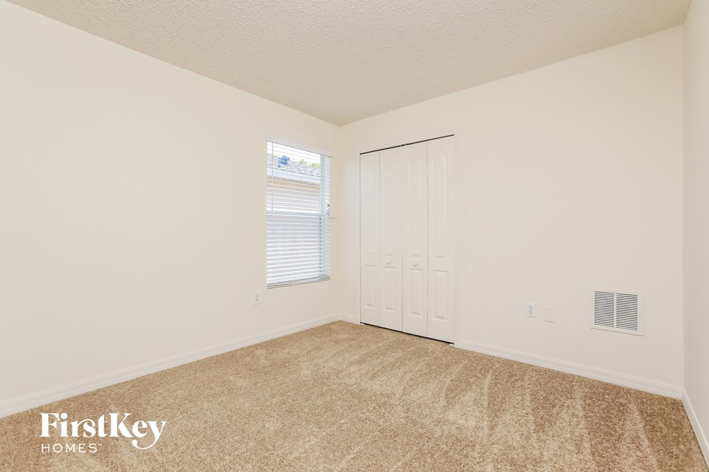 a bedroom with carpet and a door to a closet