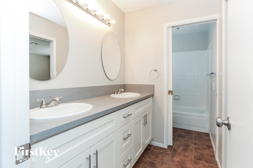 a bathroom with two sinks and a shower and a mirror