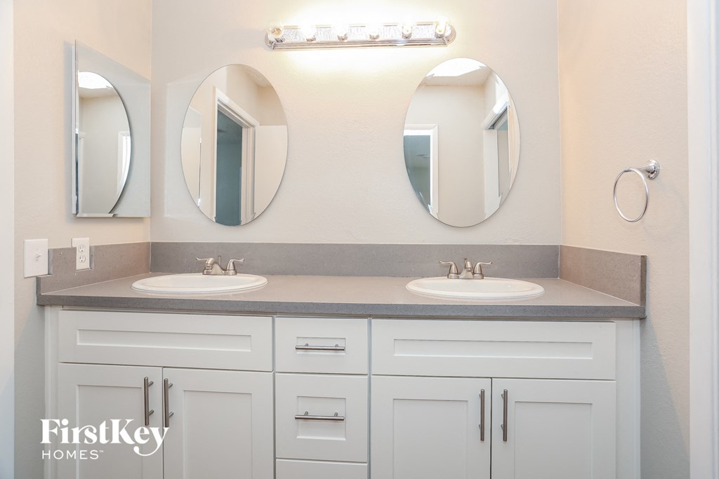 a bathroom with two sinks and three mirrors
