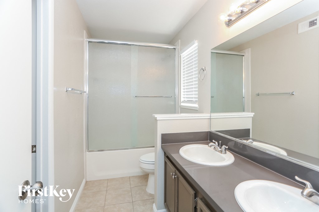 a bathroom with two sinks and a shower and a toilet