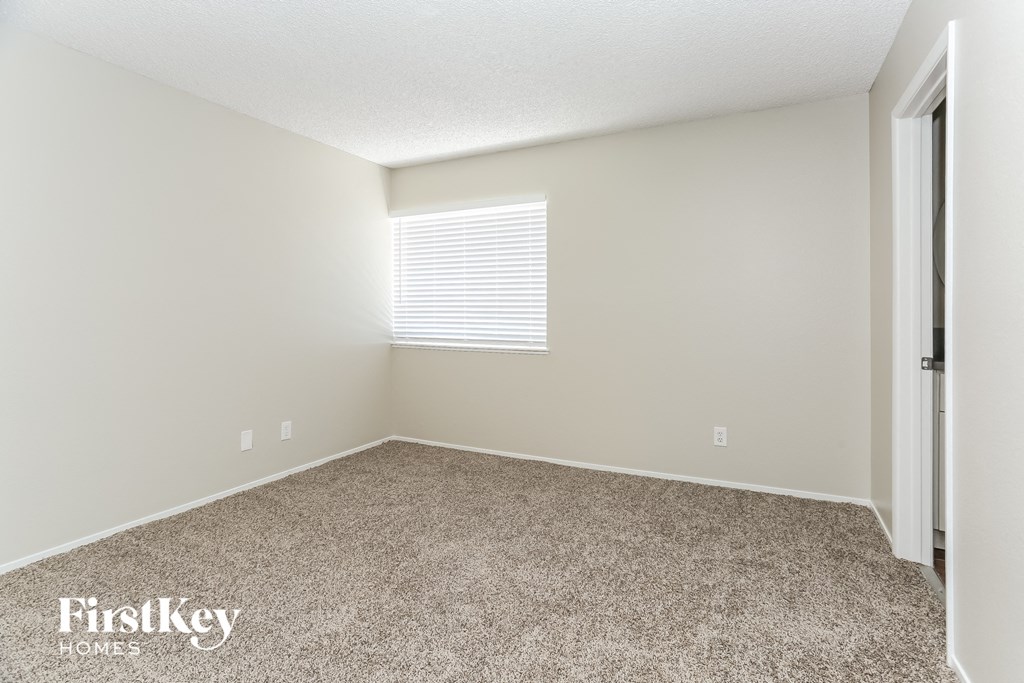 a spacious room with carpet and a window