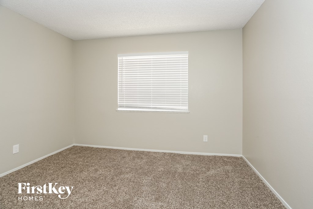 a empty room with carpet and a window