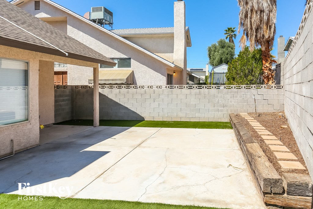 a driveway in front of a house with a retaining wall