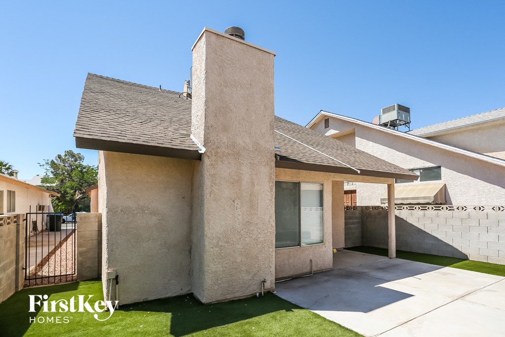 the backyard of a house with a gate and grass