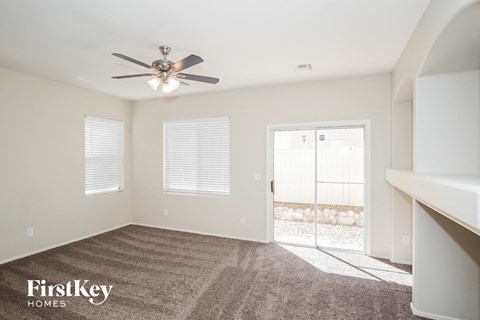 a living room with carpet and a ceiling fan