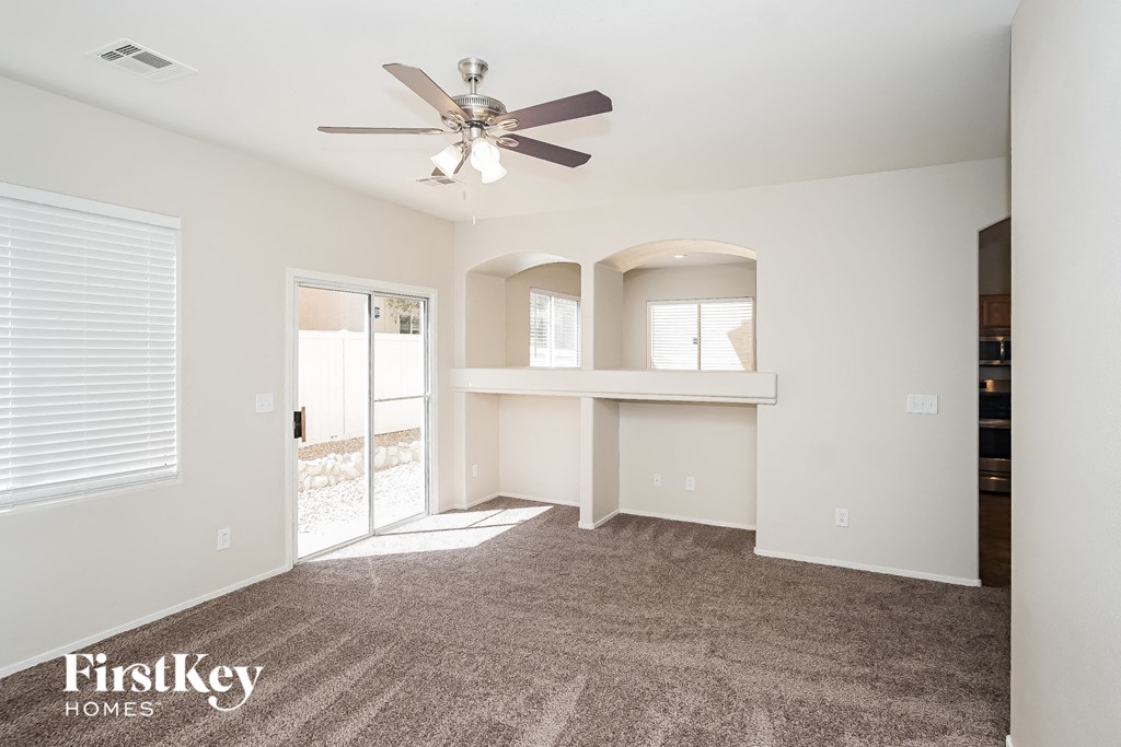 a living room with carpet and a ceiling fan