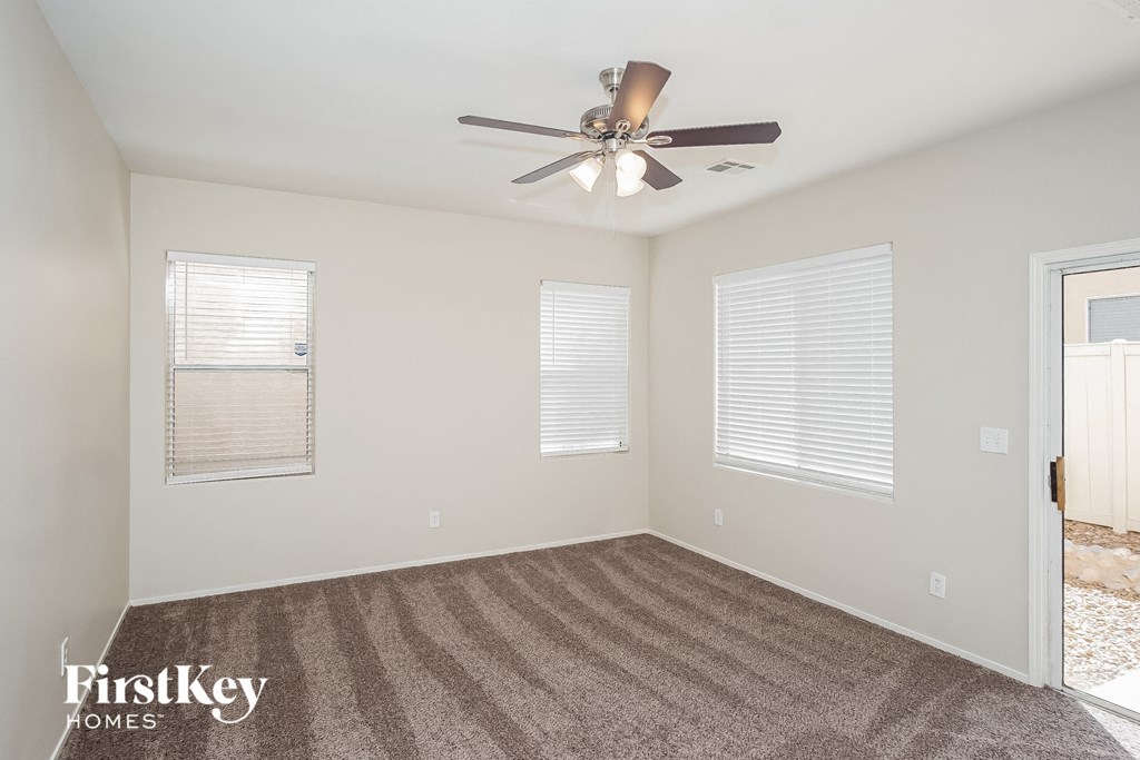 a living room with carpet and a ceiling fan