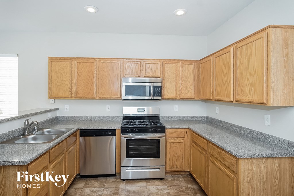 a kitchen with wooden cabinets and stainless steel appliances and granite counter tops