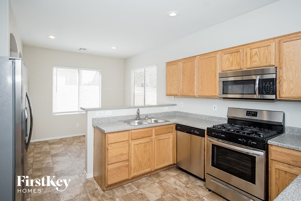 a kitchen with wooden cabinets and stainless steel appliances