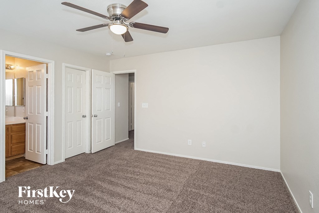 a bedroom with a carpeted floor and a ceiling fan