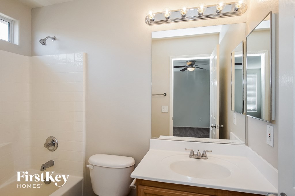 a bathroom with a toilet and a sink and a mirror
