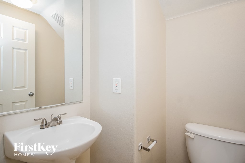 a bathroom with a toilet and a sink and a mirror