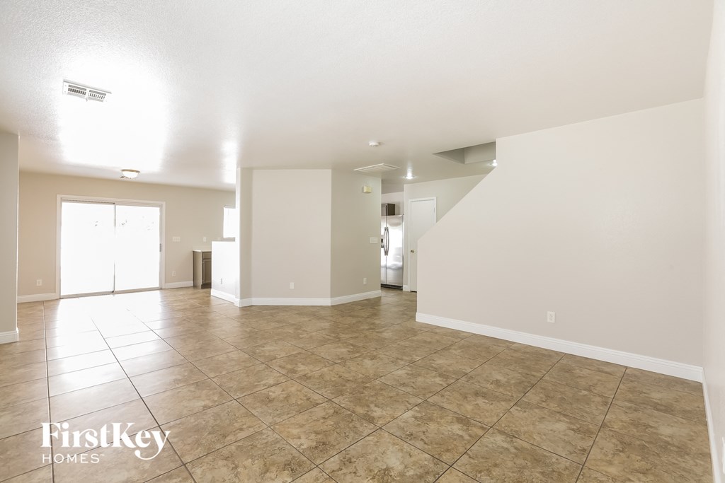 a spacious living room with tile floors and white walls