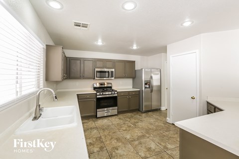 a kitchen with stainless steel appliances and white counter tops