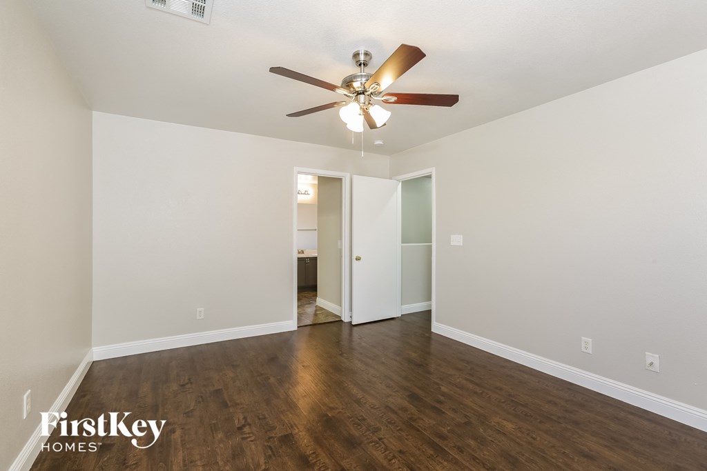 a living room with white walls and a ceiling fan