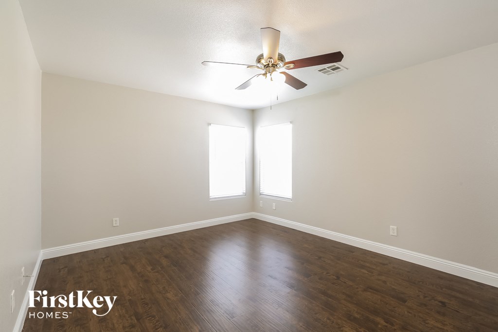 a living room with wood floors and a ceiling fan
