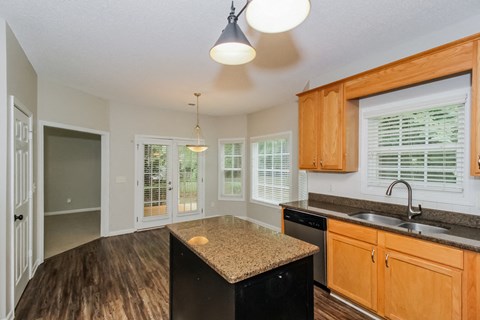 A kitchen with wooden cabinets and a granite countertop.
