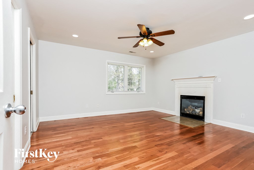 a living room with a fireplace and a ceiling fan