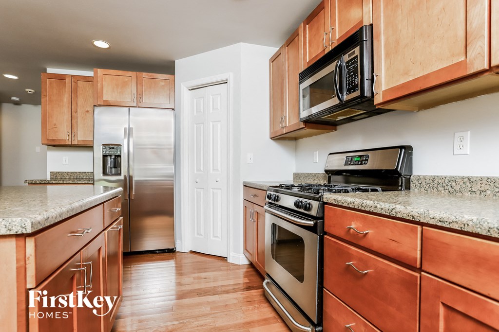 a kitchen with wood cabinets and stainless steel appliances and granite counter tops