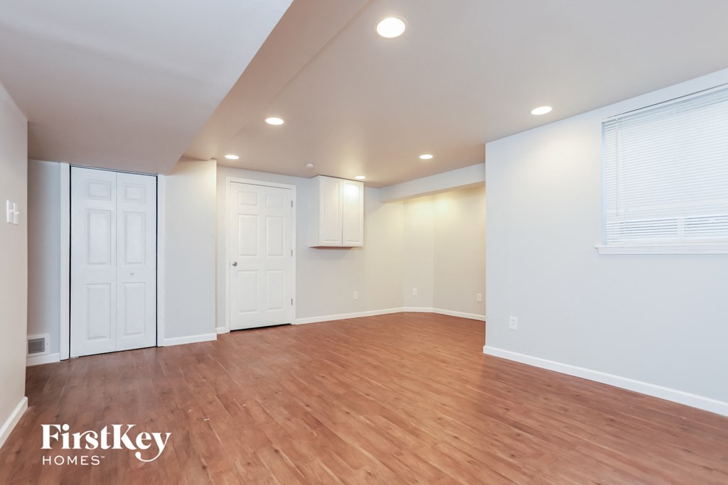 the living room with wood floors and white walls