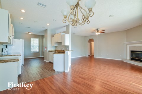 an open kitchen and living room with wood flooring