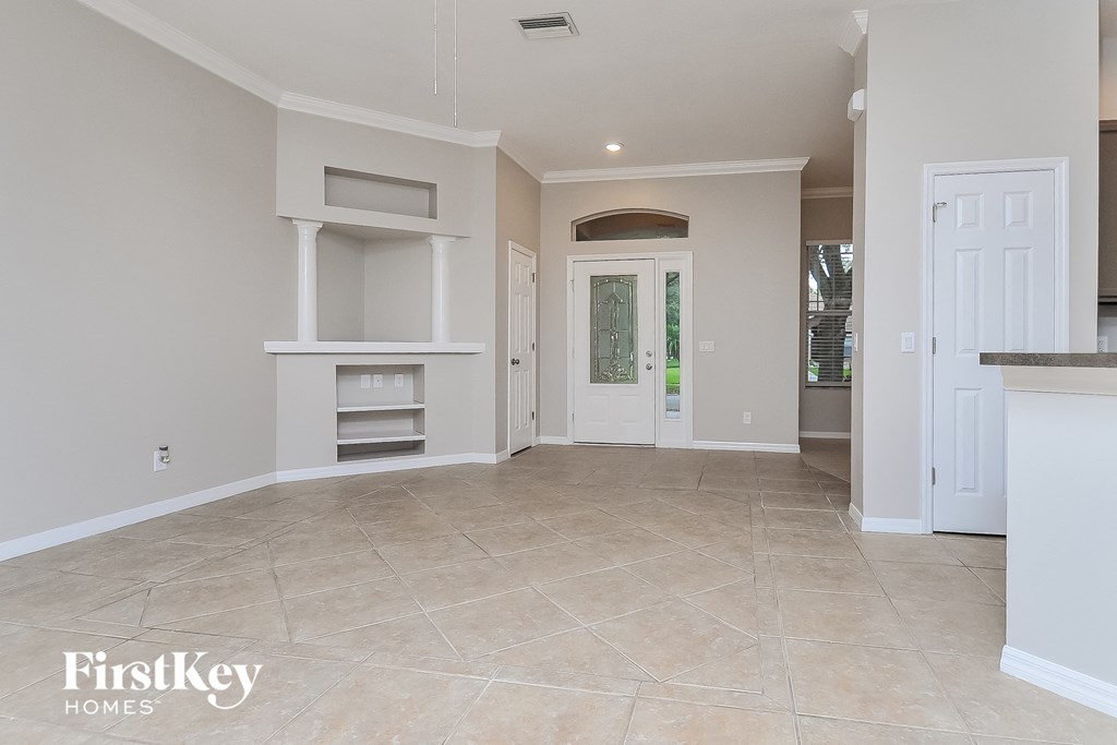 a large empty kitchen and living room with a door to the outside