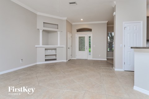 a large empty kitchen and living room with a door to the outside